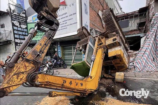 Xe múc đang tháo dỡ nhà bất ngờ lật ra đường