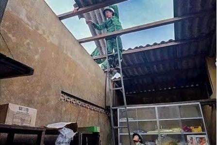Bộ đội giúp nhân dân lợp lại mái nhà sau dông lốc