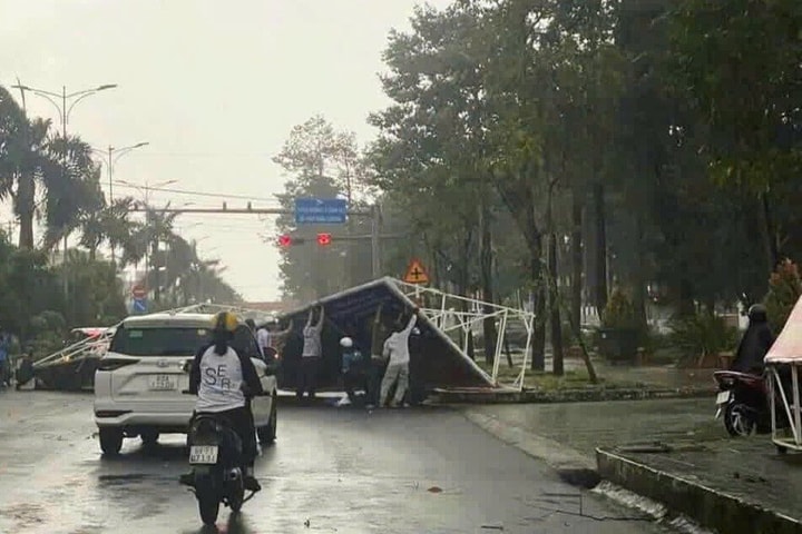 Tấm pano lớn bị gió cuốn bay đè lên người đi đường