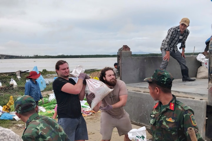 Du khách nước ngoài tham gia khắc phục bờ kè sạt lở